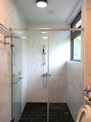 a bathroom with a shower with a glass door at Greenville Maioli in Tongxiao