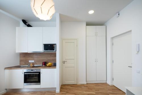 a kitchen with white cabinets and a sink at Residential Barona Apartments in Riga Centre in Rīga