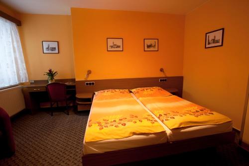 a bedroom with a bed and a desk and a table at Hotel U Jiřího in Humpolec