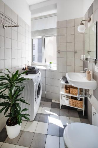 a bathroom with a washing machine and a sink at Residential Barona Apartments in Riga Centre in Rīga
