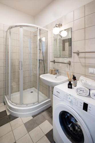 a bathroom with a shower and a washing machine at Residential Barona Apartments in Riga Centre in Rīga