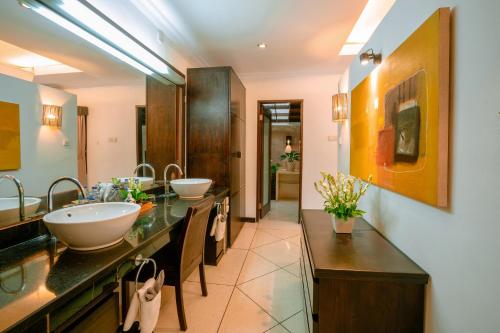 a bathroom with two sinks and two mirrors at Maya Sayang Seminyak in Seminyak