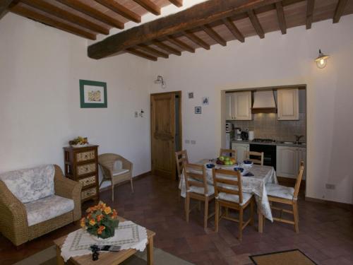 uma sala de estar com mesa e cadeiras e uma cozinha em Belvilla by OYO Forno em Castelnuovo Berardenga
