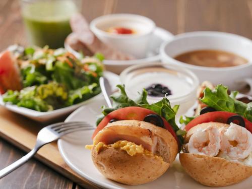 a plate of food with a salad and a bowl of soup at Hotel Areaone Kochi in Kochi