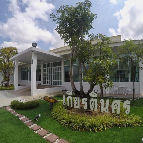 a white building with a sign in front of it at Kiatnakhon Hotel in Nakhon Si Thammarat