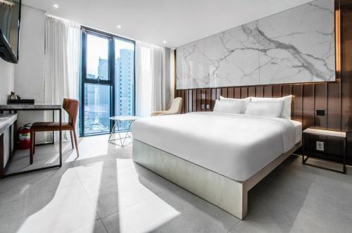 a bedroom with a large white bed and a desk at Hotel the Castle bangi 2nd in Seoul