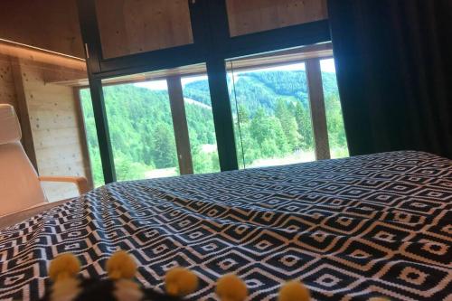 a bedroom with a bed and a large window at Bel appartement neuf équipé au pied des pistes du HONHECK in La Bresse