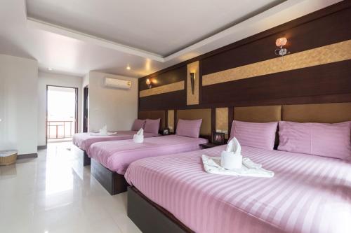 two beds in a room with pink sheets at The leaf&pool kohlarn เดอะลีฟ&พลู ที่พักเกาะล้าน in Pattaya Central