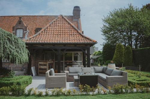 a house with a gazebo with couches at La Maison Des Papillons in Deerlijk