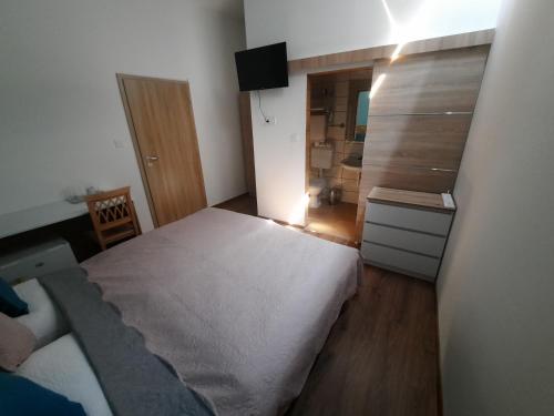 a small bedroom with a bed and a mirror at aQuarium Panzió in Abádszalók