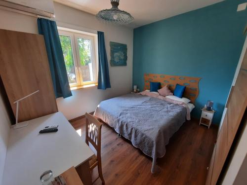 a bedroom with a bed with blue walls at aQuarium Panzió in Abádszalók