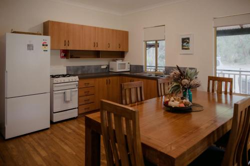 a kitchen with a table and chairs and a refrigerator at Yallingup Forest Resort in Yallingup
