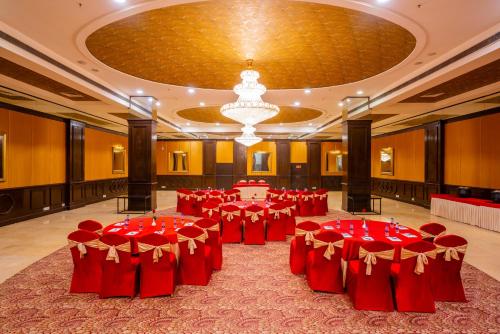 a large banquet hall with red tables and chairs at Regenta Inn Jaipur, Adarsh Nagar in Jaipur