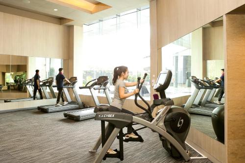 a woman running on a treadmill in a gym at Grand Mercure Jakarta Kemayoran in Jakarta