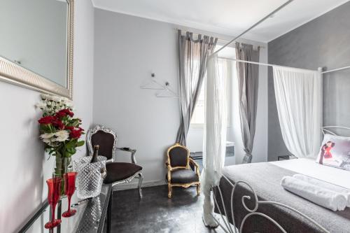 sypialnia z łóżkiem z baldachimem i 2 krzesłami w obiekcie Heart of San Lorenzo w Rzymie