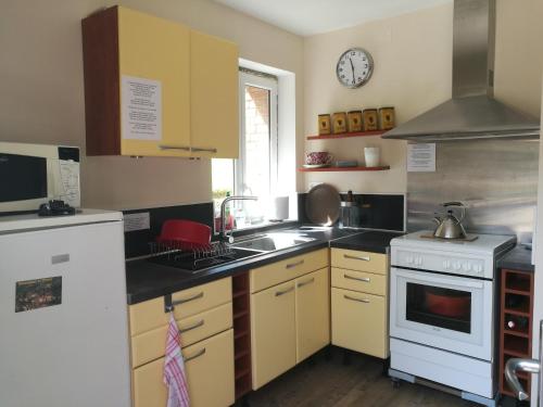 a kitchen with a sink and a stove at LODGE EXTERIEUR 2 PERSONNES (possibilité toile de tente en plus pour efants avec futon) in Saint-Aubin-sur-Gaillon