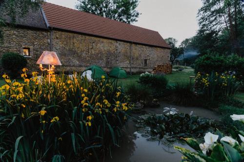 a garden with flowers in front of a building at LODGE EXTERIEUR 2 PERSONNES (possibilité toile de tente en plus pour efants avec futon) in Saint-Aubin-sur-Gaillon