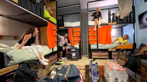 a group of people in a room with bunk beds at Carob Hostel in Amman