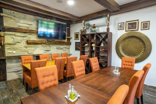a dining room with a table and chairs and a tv at Vila Jasen - Bjelašnica in Sarajevo