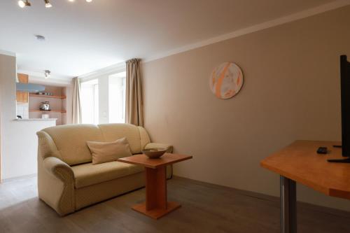 a living room with a couch and a table at Hofgut Langenborn Wohnen auf Zeit möblierte Apartments Aschaffenburg Alzenau Frankfurt in Schöllkrippen
