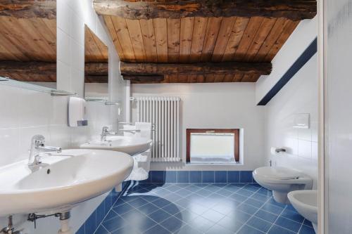 a bathroom with two sinks and two toilets at Fondazione Lucia De Conz in San Gregorio nelle Alpi,