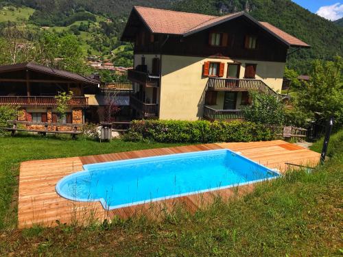 a swimming pool in front of a house at Appartamenti Lembondel - Ledro in Tiarno di Sotto