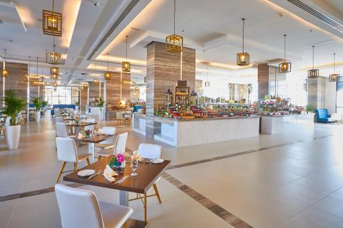 a restaurant with tables and chairs and a bar at Al Bahar Hotel & Resort in Fujairah