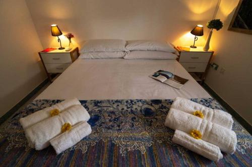 een slaapkamer met een groot bed en handdoeken bij VILLA TIMEA in Castrignano del Capo