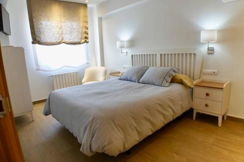 a bedroom with a bed and a table and a window at El paraiso de Anita in Benicàssim