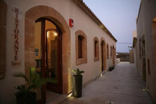 a building with an alley with a potted plant next to it at Life Hotels Kalaonda Resort in Siracusa