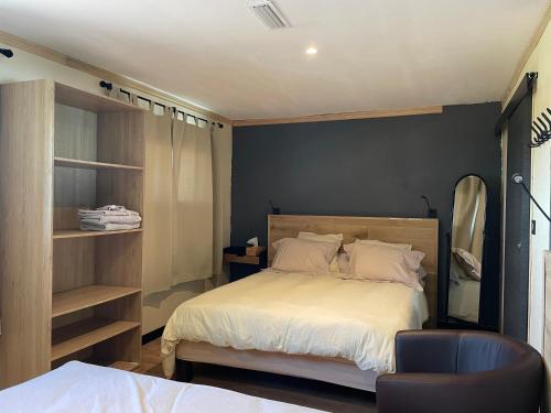 une chambre avec un grand lit et une chaise dans l'établissement Petite maison en pleine campagne, à Labastide-Gabausse