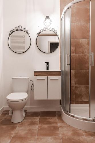 a bathroom with a toilet and a mirror at Apartament dwupokojowy in Świnoujście