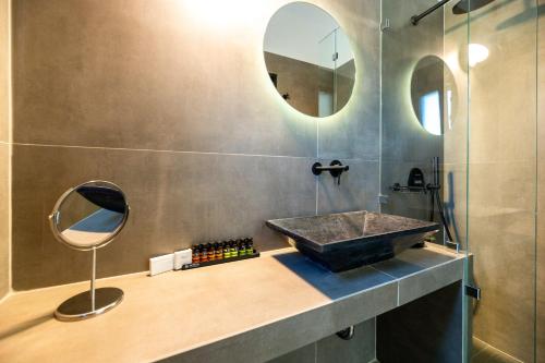 a bathroom with a sink and a mirror at Omilos Beachfront House in Parikia