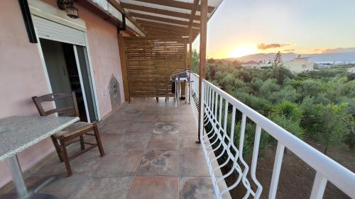 a balcony of a house with a table and chairs at Momentum Θ in Maleme