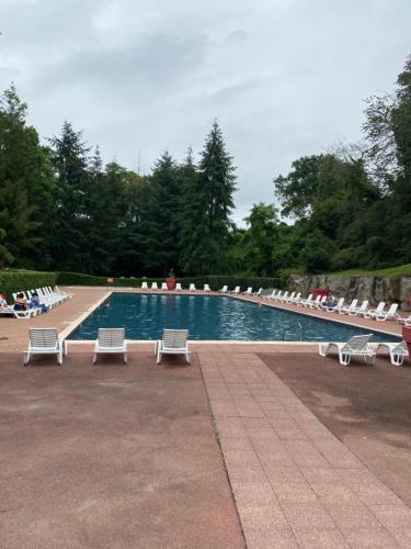- une piscine avec des chaises longues blanches et une rangée d'ofitures dans l'établissement Mobil-Home avec belle exposition, à Saint-Chéron