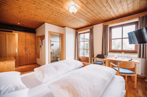 a bedroom with two white beds and a desk at Weinhotel Maitz Wolfgang in Ratsch an der Weinstraße