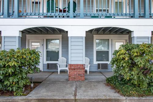two white chairs sitting on the porch of a house at 09 Lodge Near Downtown Hood River in Hood River