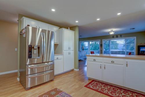 a kitchen with a stainless steel refrigerator and white cabinets at Northern Lights home in White Salmon