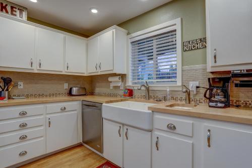 a kitchen with white cabinets and a window at Northern Lights home in White Salmon