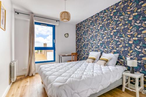 ノワールムーティエにあるSejournez dans ce charmant appartement au coeur de Noirmoutier en l Ileの花柄の壁のベッドルーム1室(大型ベッド1台付)