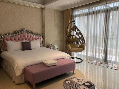 a bedroom with a large bed and a chair at Lane 82 Hostel in Chiayi City