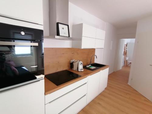 a kitchen with white cabinets and a counter top at Zum Hofgassl Haus Flo in Mörbisch am See