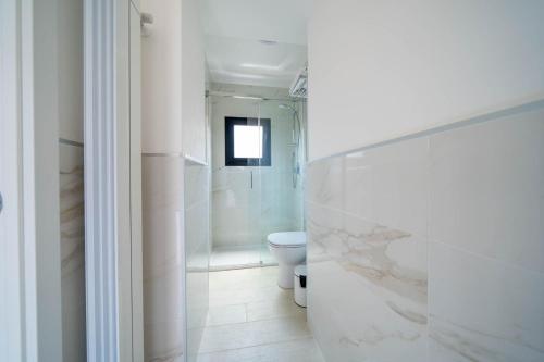 y baño blanco con aseo y ducha. en Beat House&Apartments, en Agrate Brianza