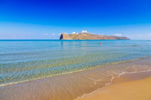 a beach with a small island in the ocean at Momentum Θ in Maleme