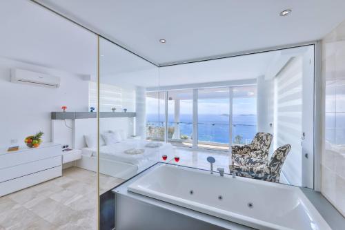 a white bathroom with a tub and a window at Villa Hill Side 2 in Kalkan