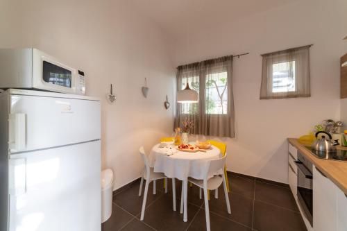 uma cozinha com uma mesa branca e um frigorífico branco em Apartment One em Okrug Donji