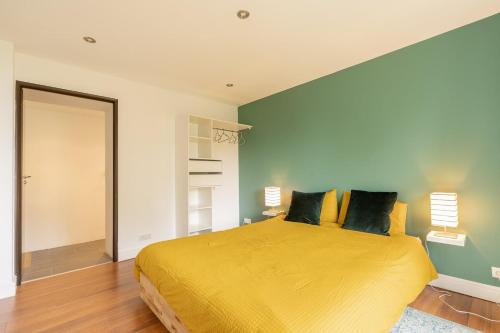 a bedroom with a large yellow bed with yellow pillows at Ecrin cosy au coeur de Thollon (Sauna !) in Thollon