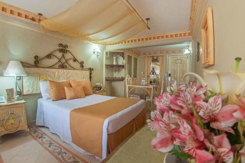 um quarto com uma cama e flores num quarto em Villa las Margaritas Plaza Cristal em Xalapa