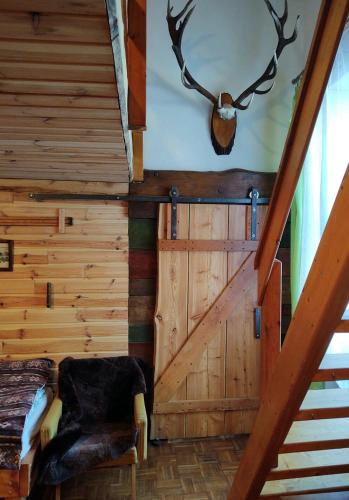 a room with wooden walls and a chair and a door at Apartman Tri Duby Tatranská Lomnica in Tatranská Lomnica