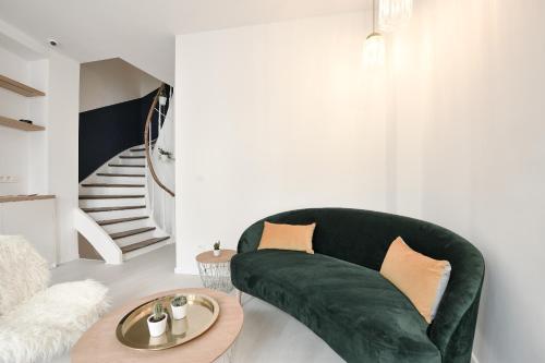 a living room with a green couch and a table at Urban Walls in Brussels